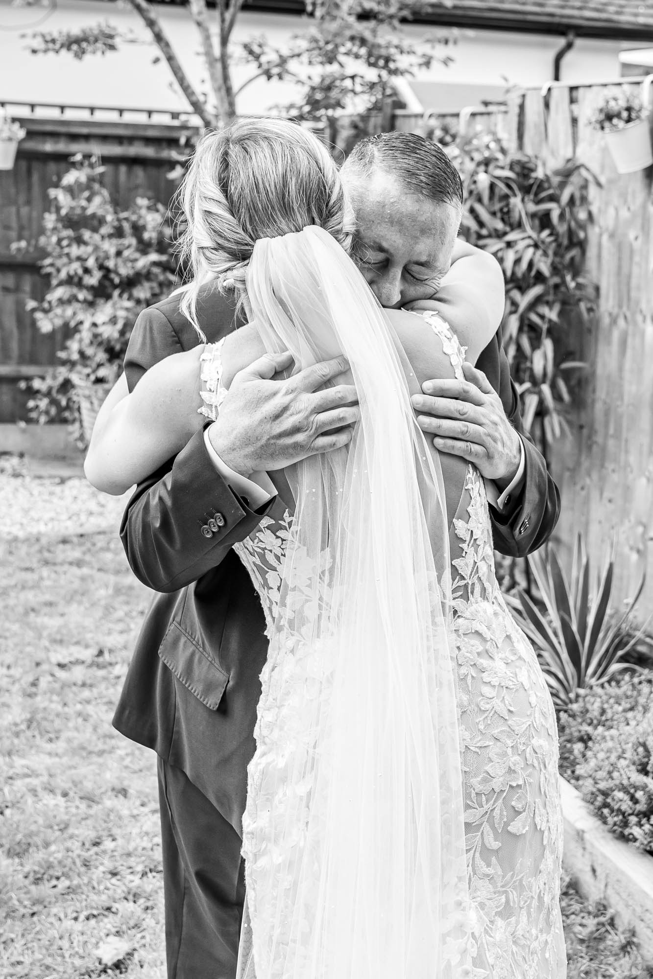 Bride hugs her father.