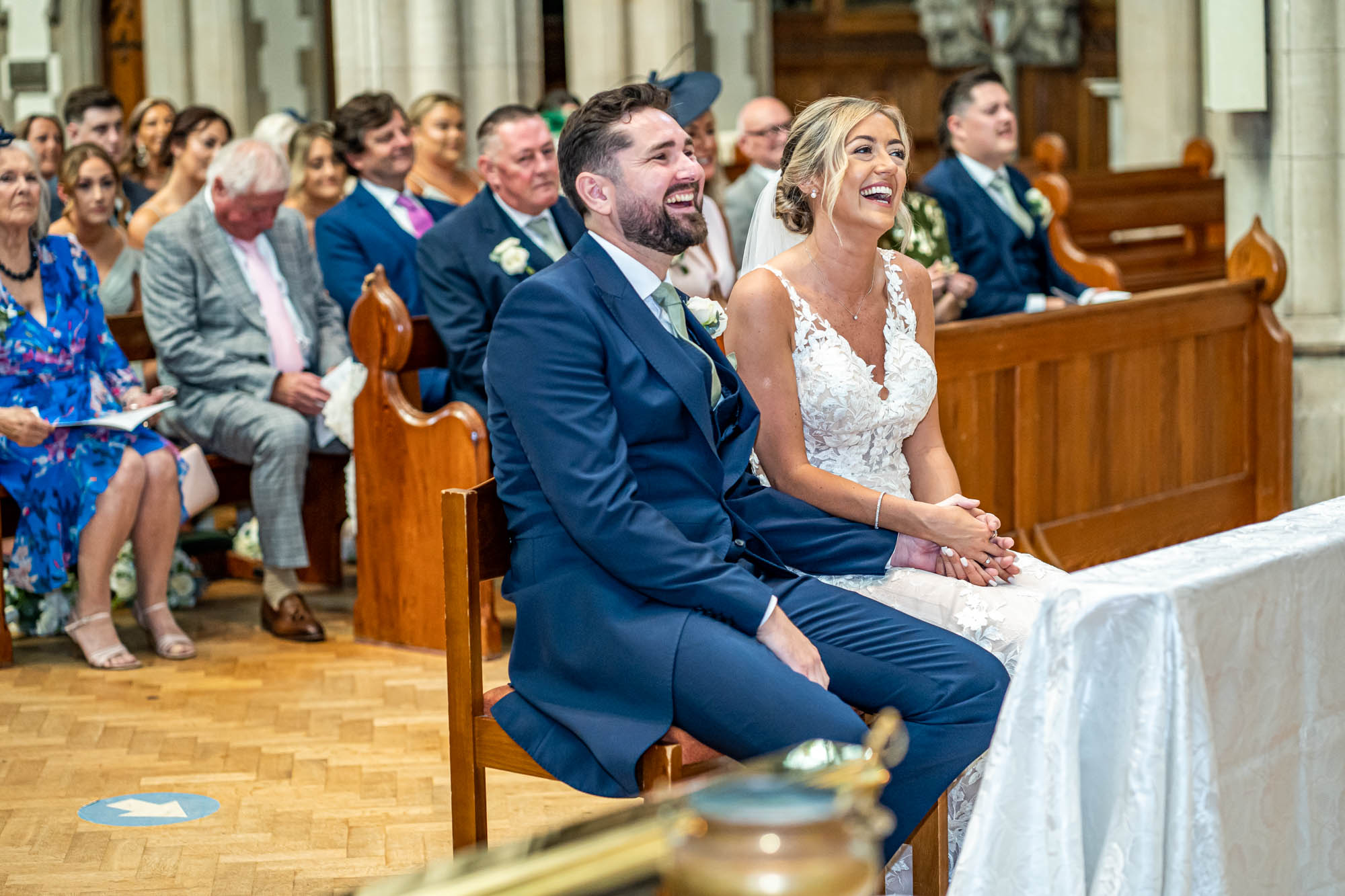 Groom and bride laugh together during their wedding ceremony.