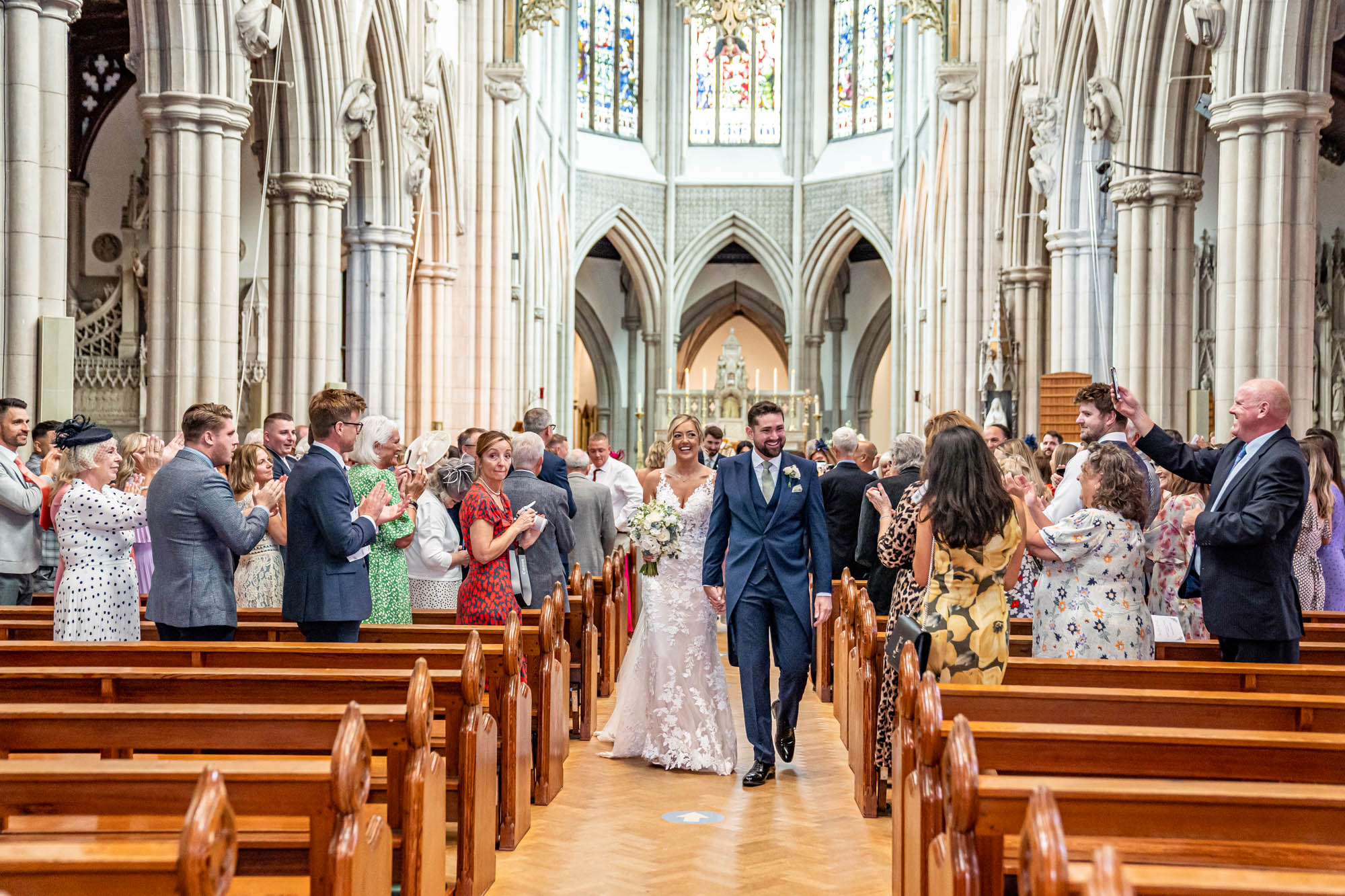 Newlyweds walk down the aisle together in church.