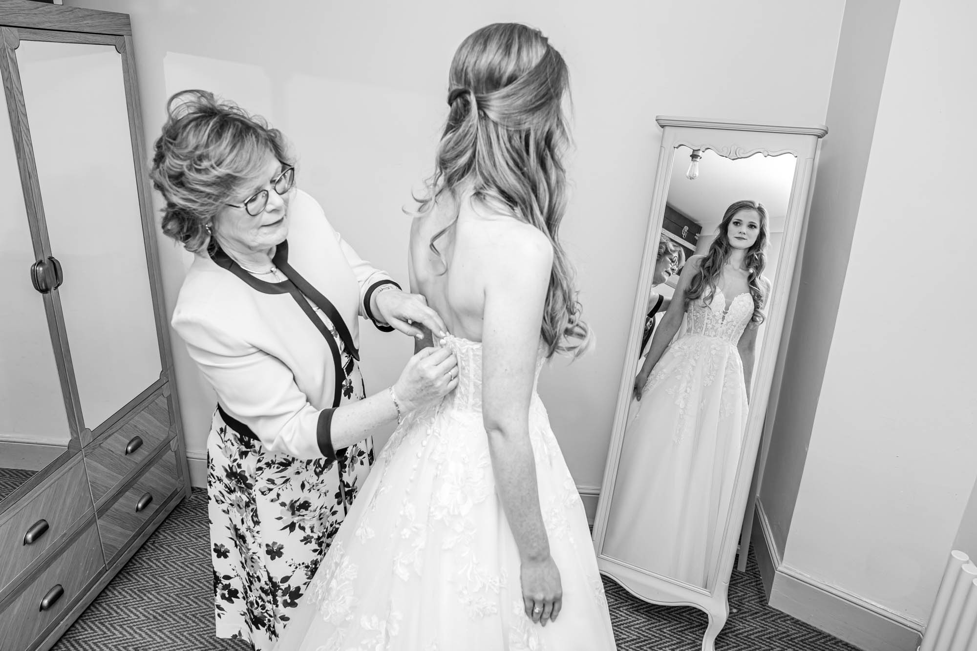 Mother of the bride dresses her daughter.