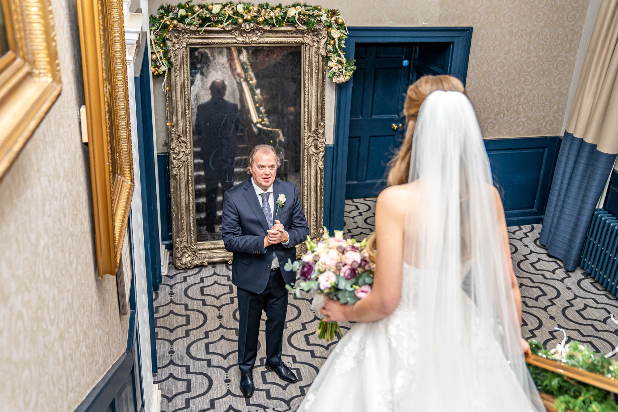 Bride reveals wedding dress to her father.