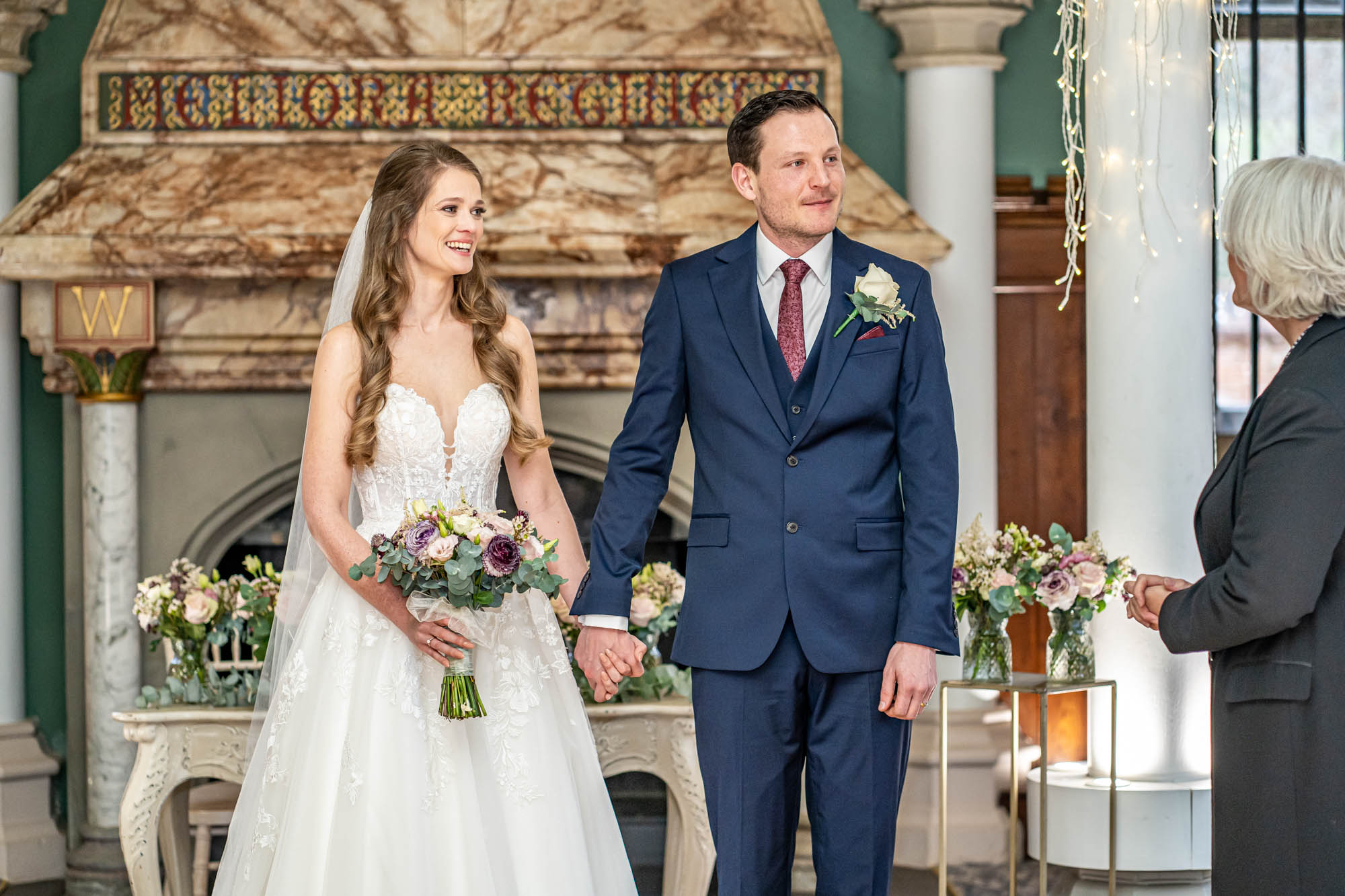 Groom holds hands with his bride.