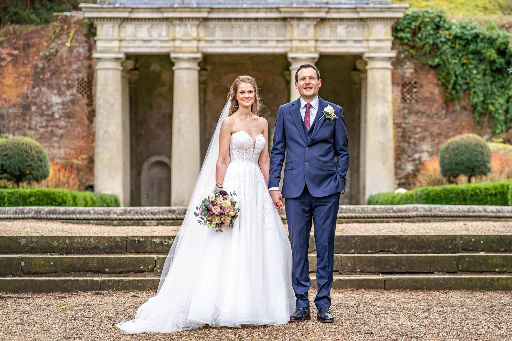 Groom and bride standing together in front of the Italian temple.