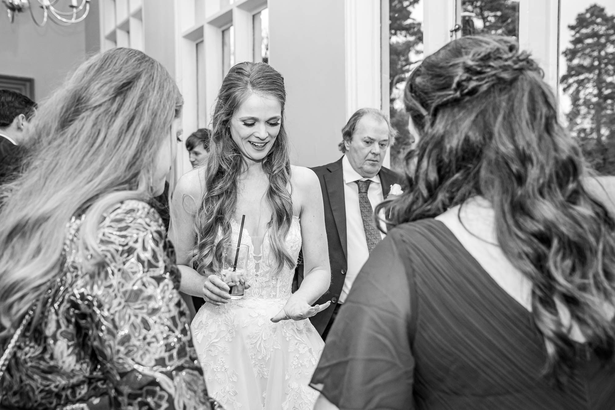 Bride shows her wedding ring off to her guests.